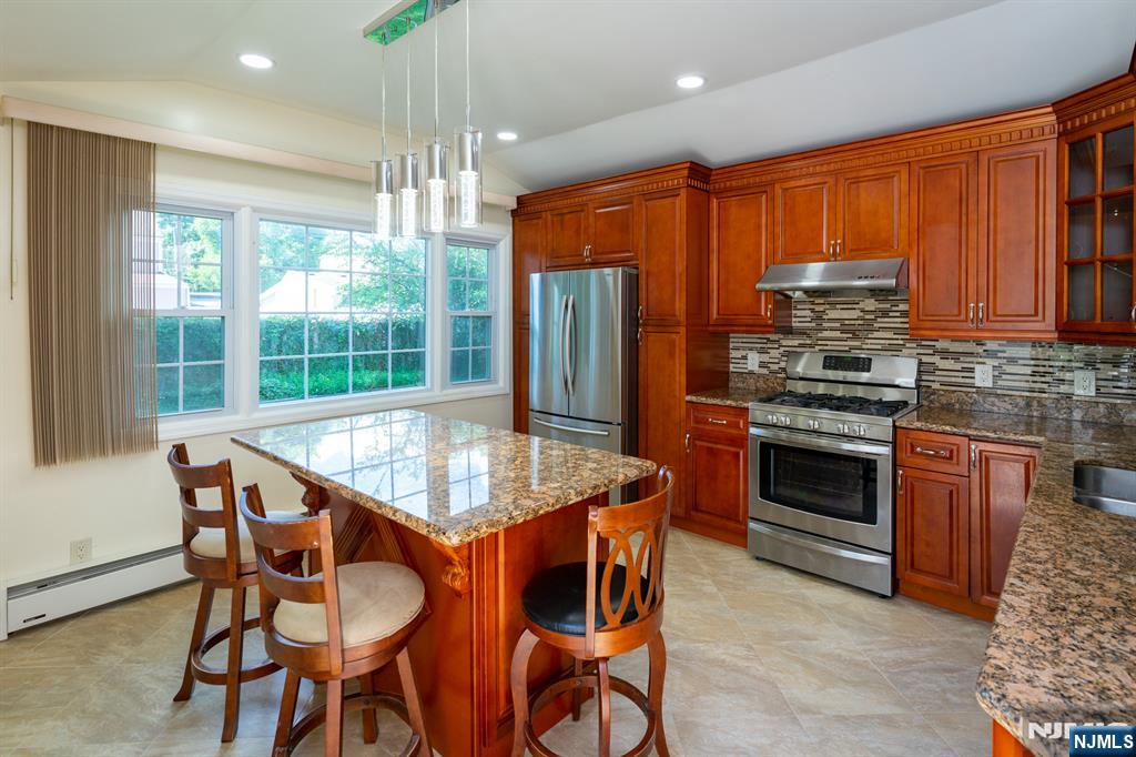 397 Hickory Avenue Paramus, NJ 07652 - Photo 5 of 14 a kitchen with stainless steel appliances granite countertop wooden floor dining table and chairs