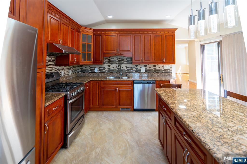 397 Hickory Avenue Paramus, NJ 07652 - Photo 6 of 14 a kitchen with stainless steel appliances granite countertop a stove a sink and a refrigerator
