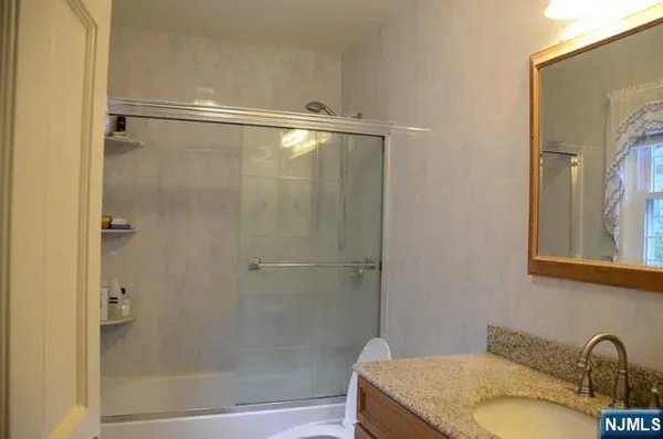 a bathroom with a granite countertop shower and a sink