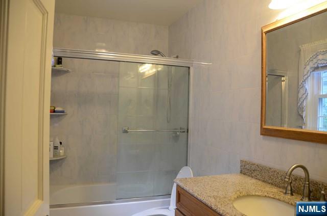 397 Hickory Avenue Paramus, NJ 07652 - Photo 9 of 14 a bathroom with a granite countertop shower and a sink