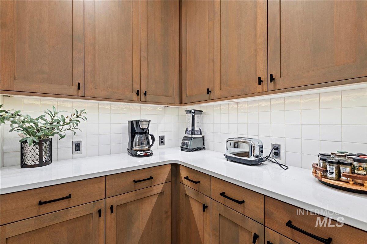 280 North Boulder Rdg Way Eagle, ID 83616 - Photo 17 of 50 Kitchen featuring brown cabinets and tasteful backsplash