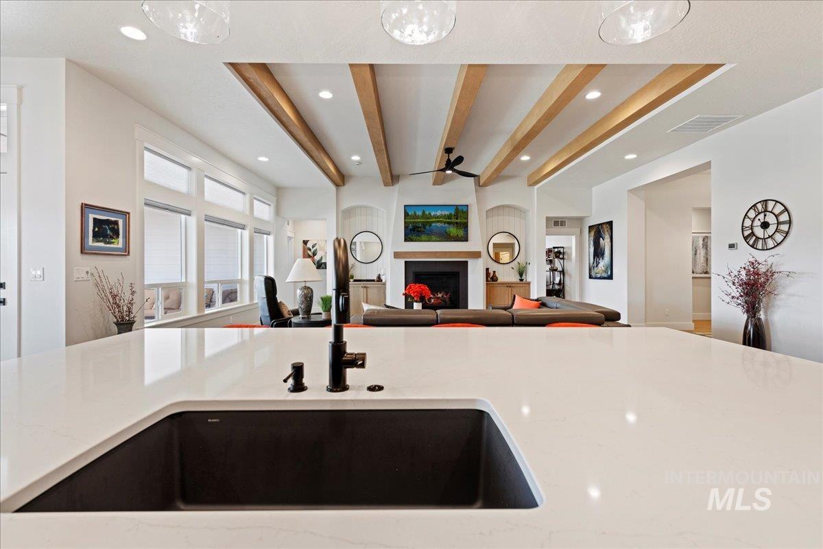 280 North Boulder Rdg Way Eagle, ID 83616 - Photo 49 of 50 Kitchen with beamed ceiling, light stone counters, a fireplace, open floor plan, and recessed lighting