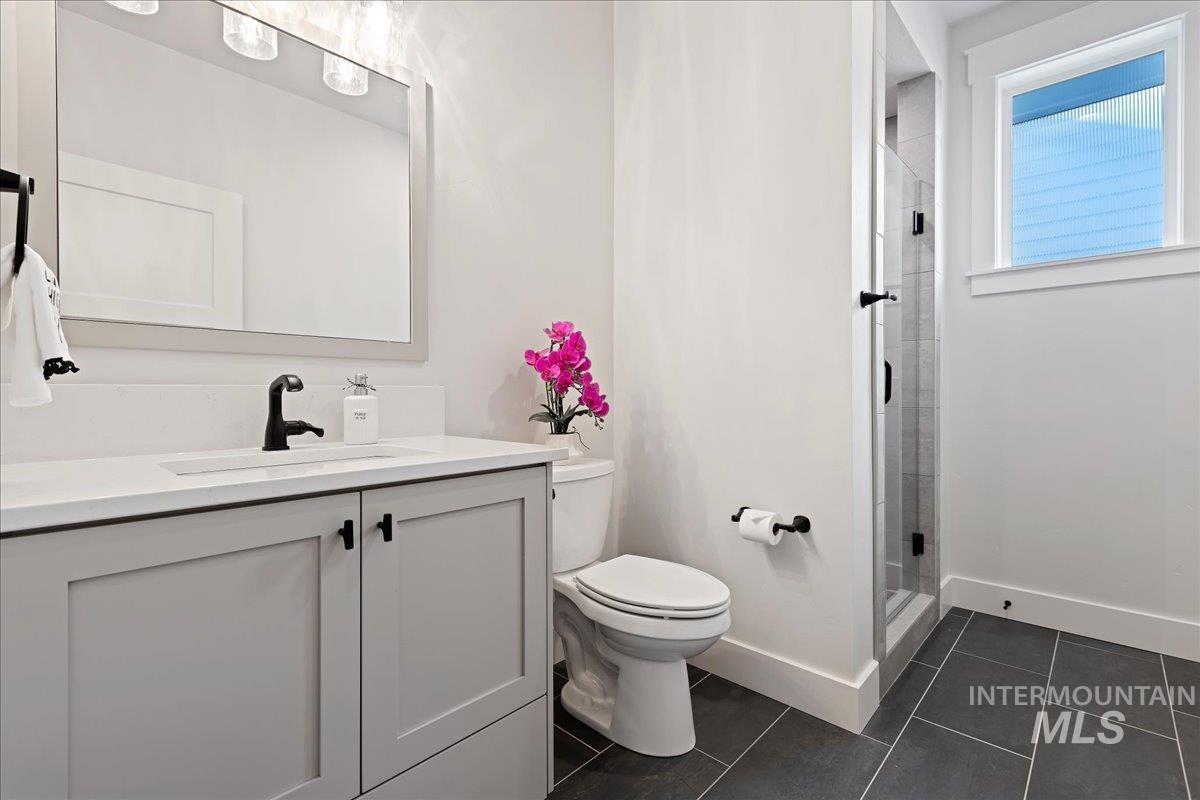 280 North Boulder Rdg Way Eagle, ID 83616 - Photo 23 of 50 Full bath with a shower stall, vanity, and dark tile patterned floors