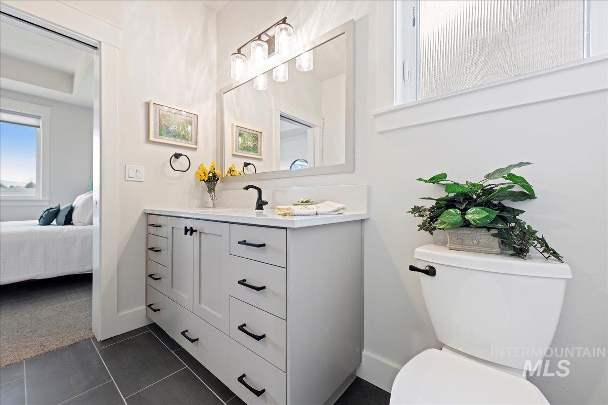 280 North Boulder Rdg Way Eagle, ID 83616 - Photo 29 of 50 Half bath with vanity, dark tile patterned floors, ensuite bath, and dark carpet