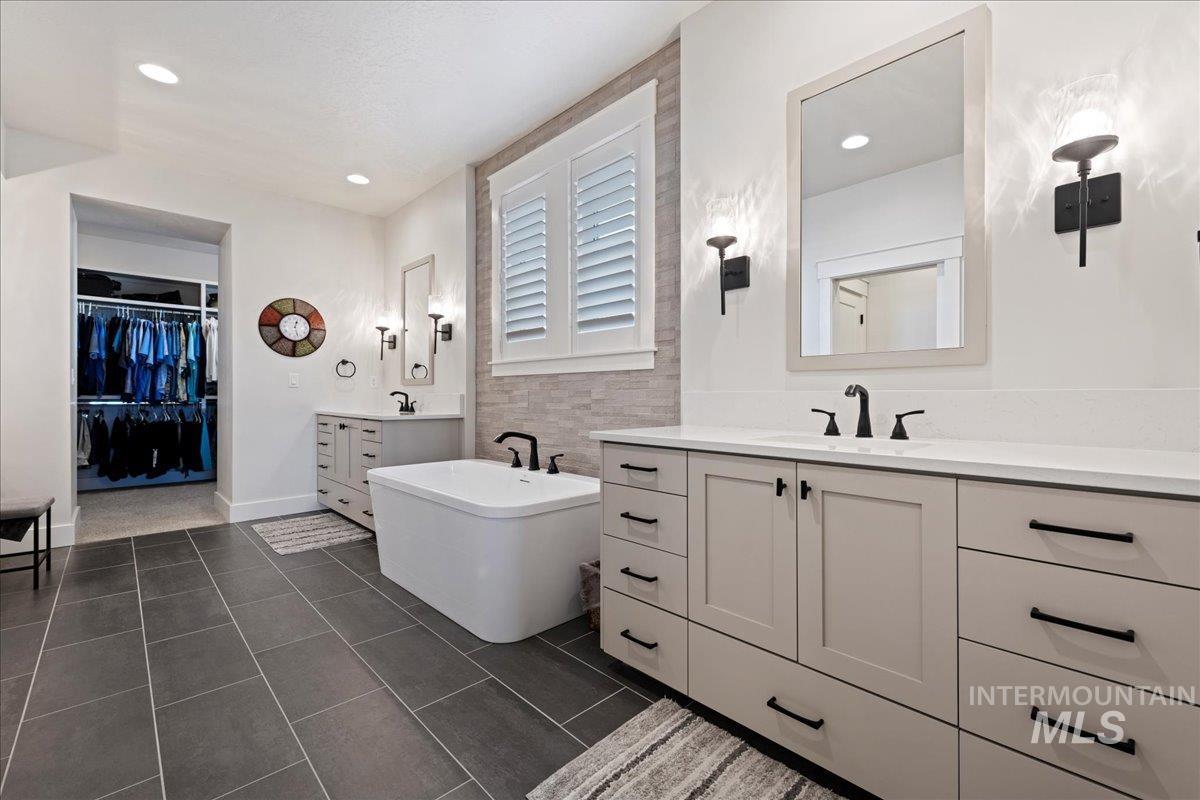 280 North Boulder Rdg Way Eagle, ID 83616 - Photo 34 of 50 Full bath featuring a freestanding bath, two vanities, a walk in closet, dark tile patterned flooring, and recessed lighting