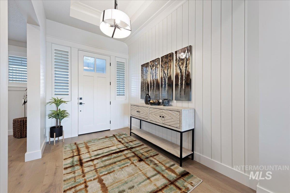 280 North Boulder Rdg Way Eagle, ID 83616 - Photo 5 of 50 Entryway featuring light wood finished floors, a raised ceiling, and wood walls