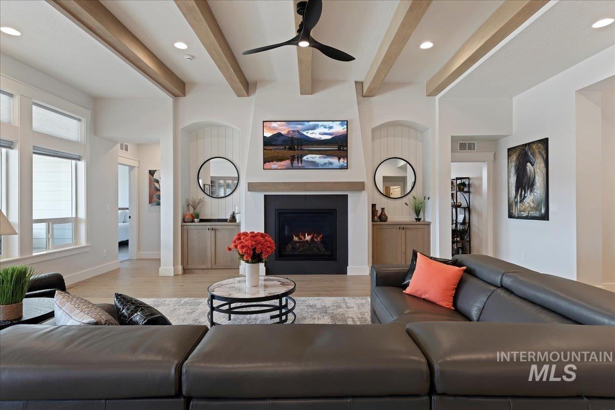 280 North Boulder Rdg Way Eagle, ID 83616 - Photo 9 of 50 Living area with a fireplace, light wood-type flooring, recessed lighting, beamed ceiling, and a ceiling fan