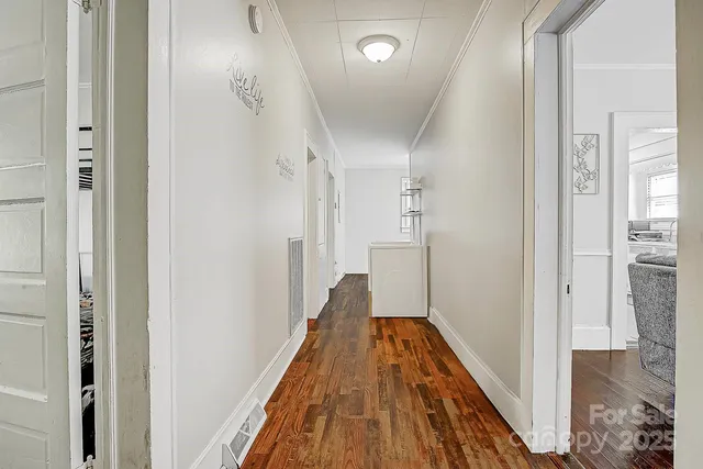 a view of a hallway with wooden floor and staircase