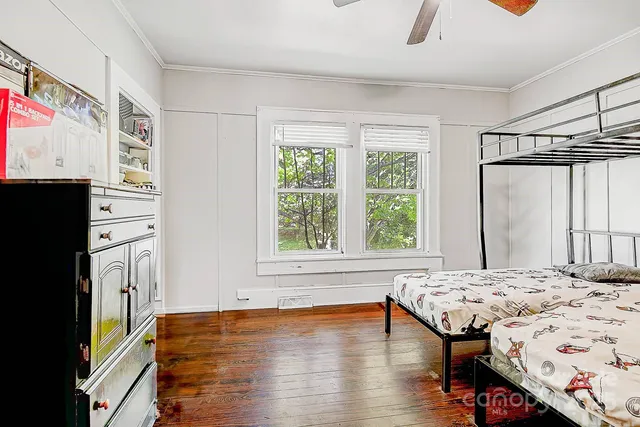 a bedroom with a bed and a dresser next to a window