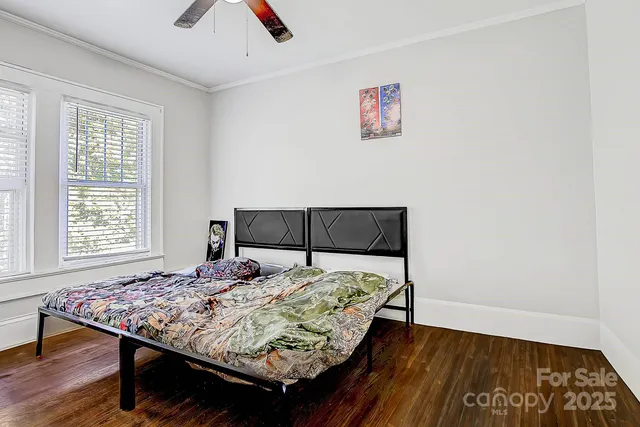 a bed sitting in a bedroom next to a window with a large center