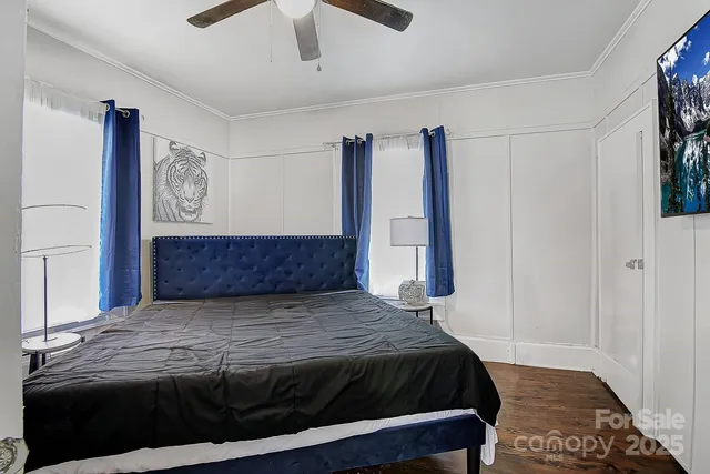 a bedroom with a large bed and a chandelier