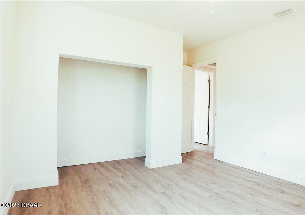 823 Berkshire Road Daytona Beach, FL 32117 - Photo 12 of 13 a view of an empty room with wooden floor