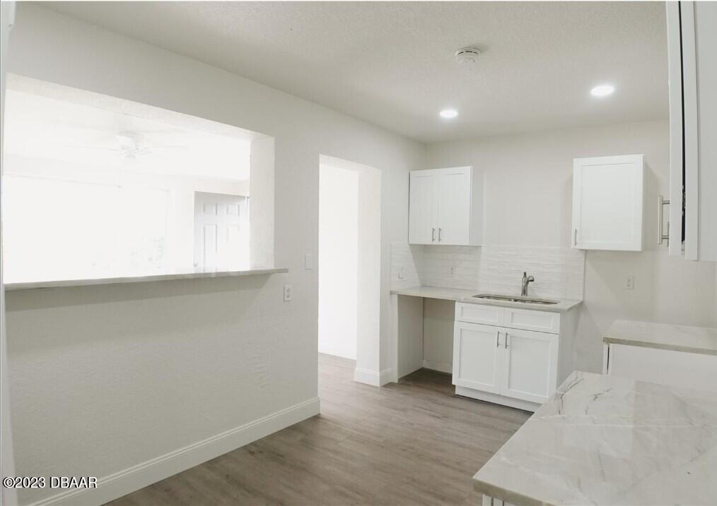 823 Berkshire Road Daytona Beach, FL 32117 - Photo 3 of 13 a kitchen with granite countertop white cabinets and white appliances