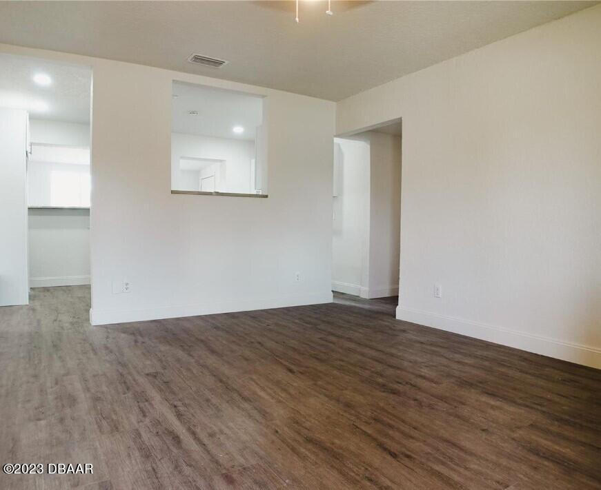 823 Berkshire Road Daytona Beach, FL 32117 - Photo 4 of 13 a view of an empty room with wooden floor and a window