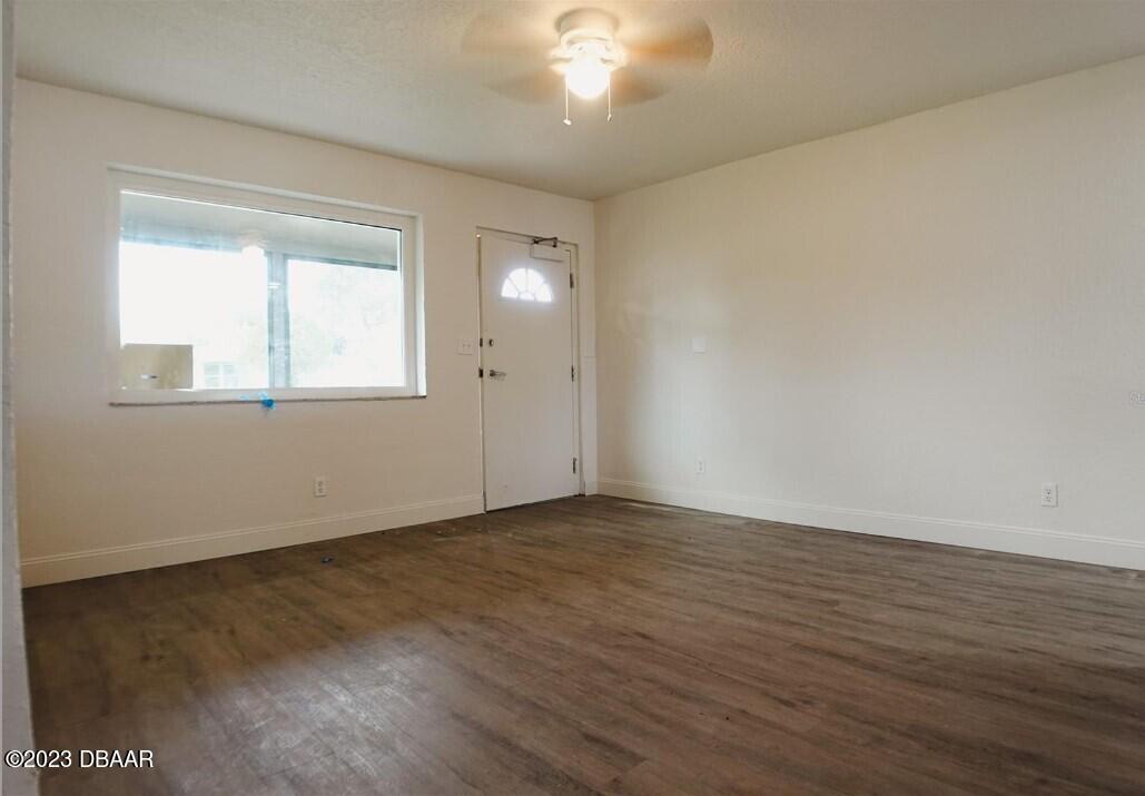 823 Berkshire Road Daytona Beach, FL 32117 - Photo 5 of 13 an empty room with wooden floor and windows