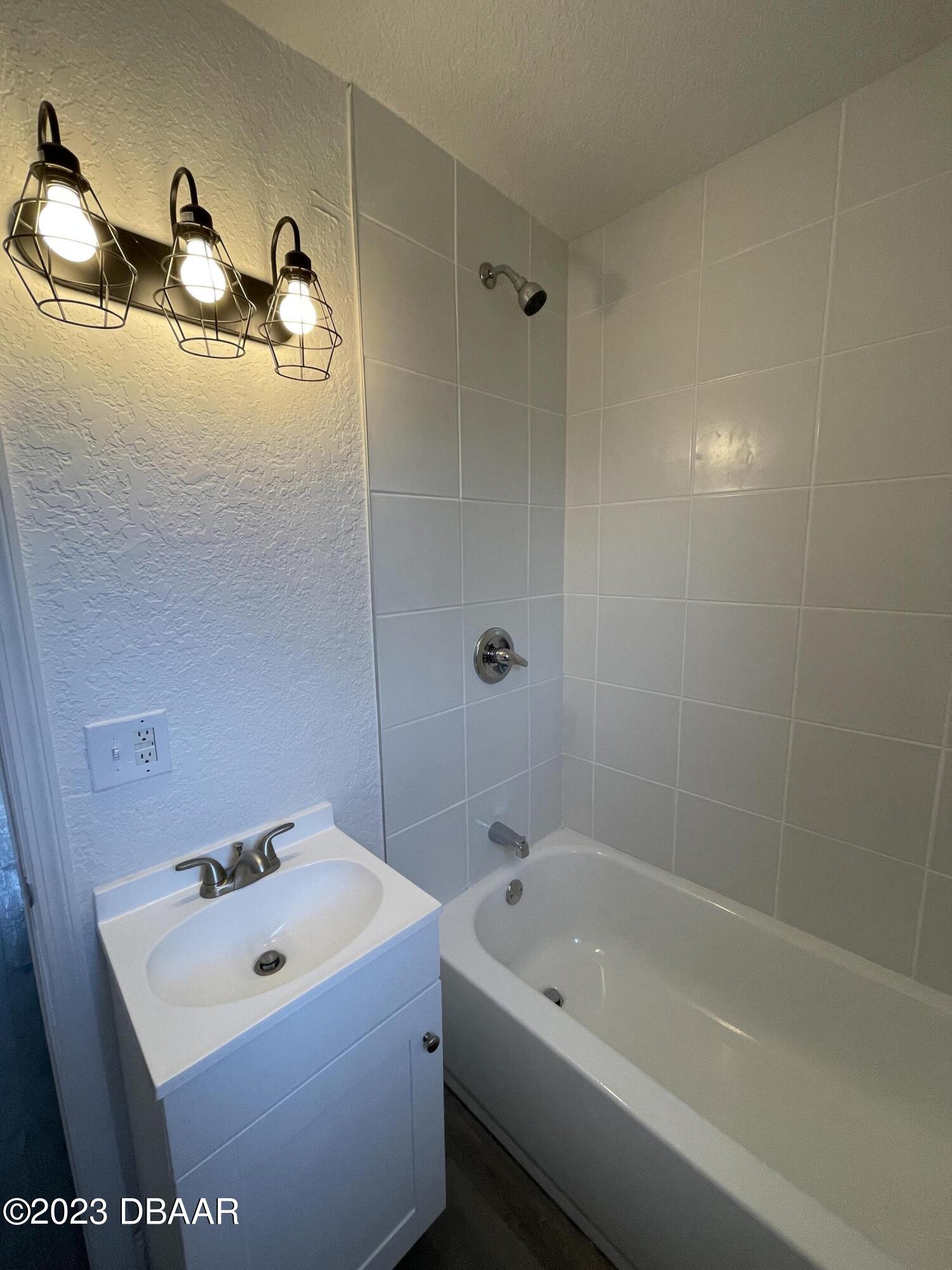 823 Berkshire Road Daytona Beach, FL 32117 - Photo 7 of 13 a bathroom with a tub a sink and mirror