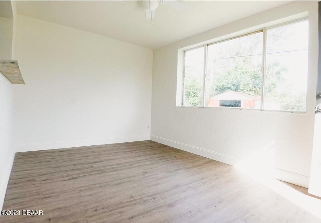 823 Berkshire Road Daytona Beach, FL 32117 - Photo 8 of 13 an empty room with wooden floor and windows