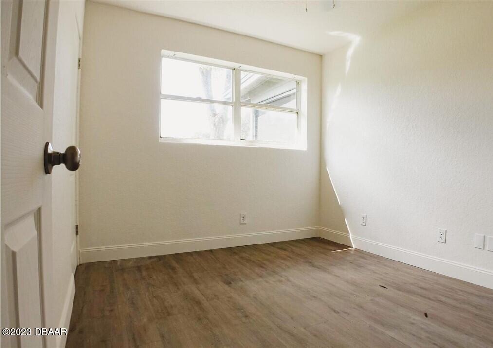 823 Berkshire Road Daytona Beach, FL 32117 - Photo 9 of 13 an empty room with wooden floor and windows