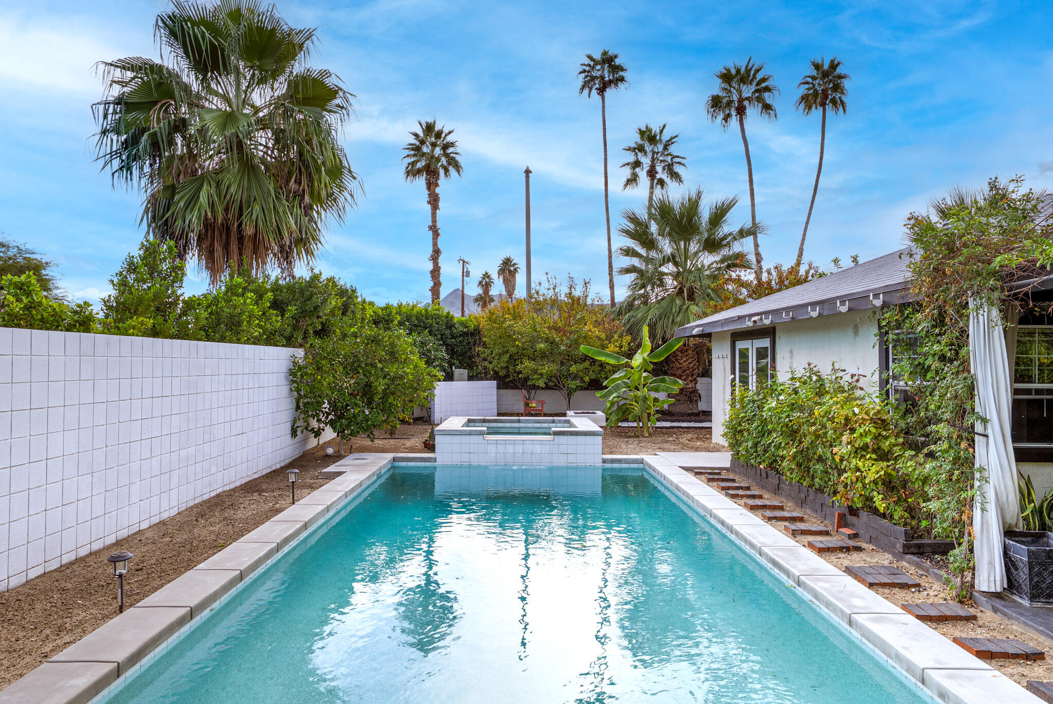 3882 East Sunny Dunes Road Palm Springs, CA 92264 - Photo 2 of 34 a view of a house with pool lawn chairs and a fire pit