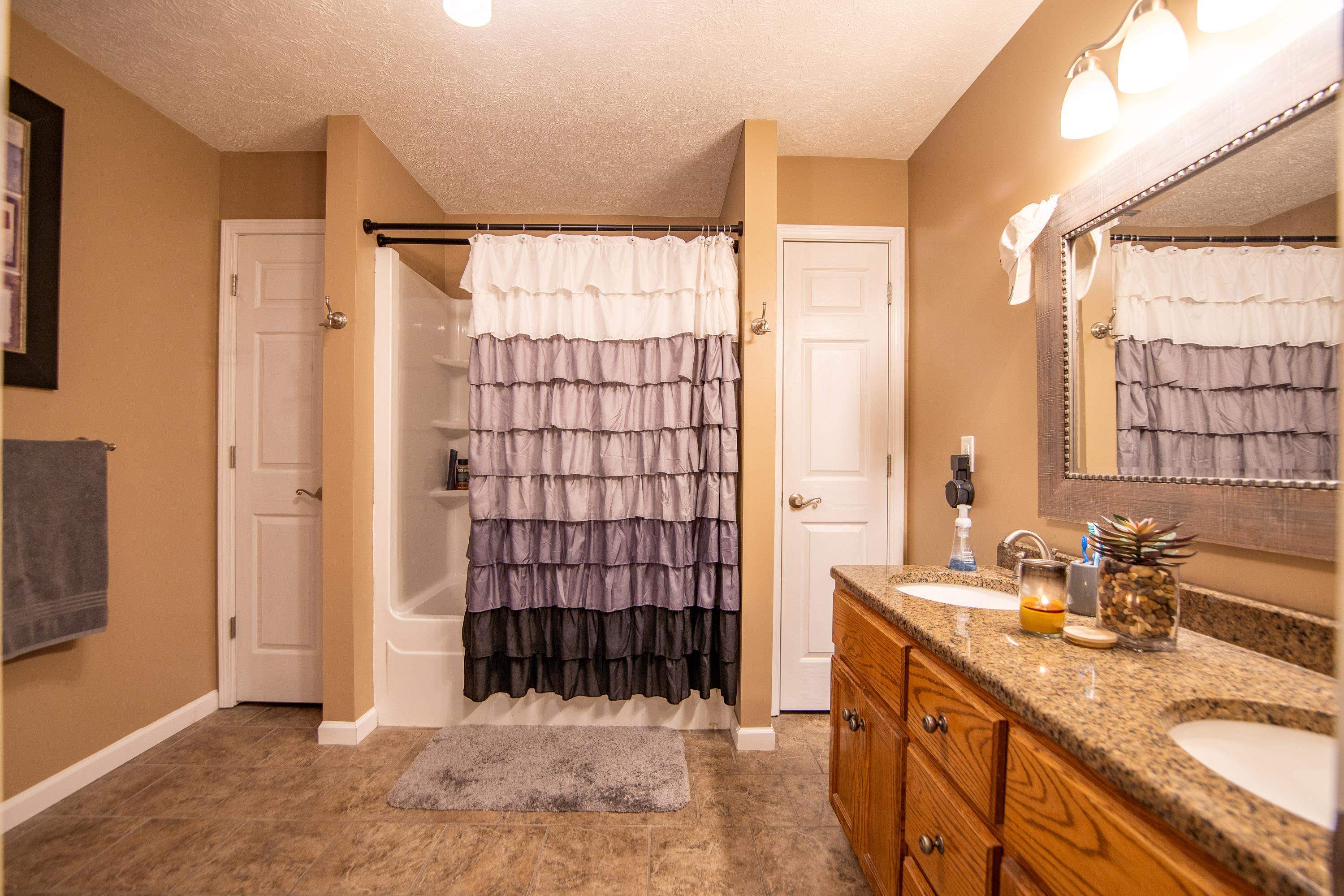 6843 Michie Pebble Hill Road Michie, TN 38357 - Photo 14 of 25 a bathroom with a granite countertop sink a mirror and shower