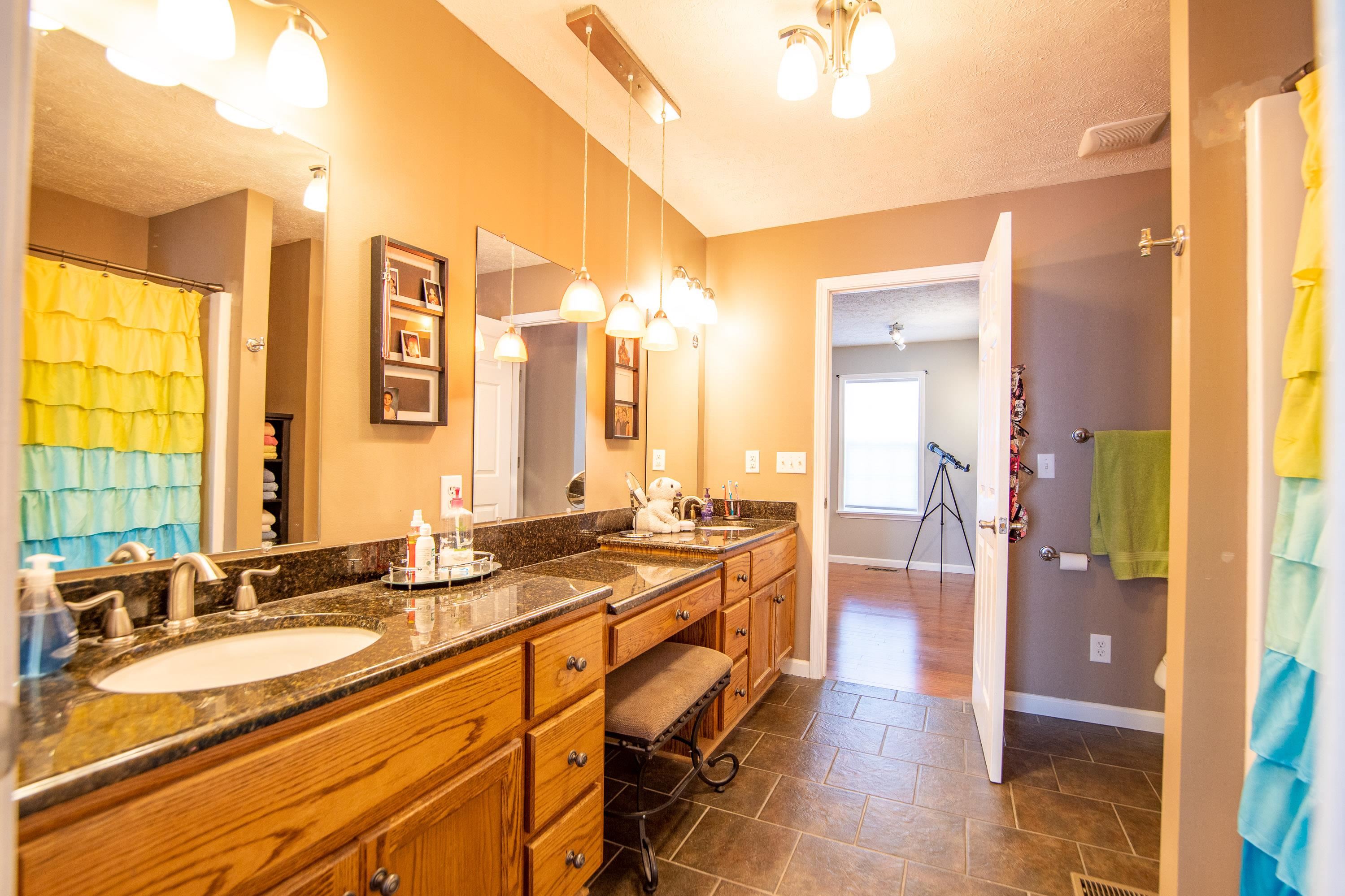 6843 Michie Pebble Hill Road Michie, TN 38357 - Photo 18 of 25 a spacious bathroom with a granite countertop sink and a mirror