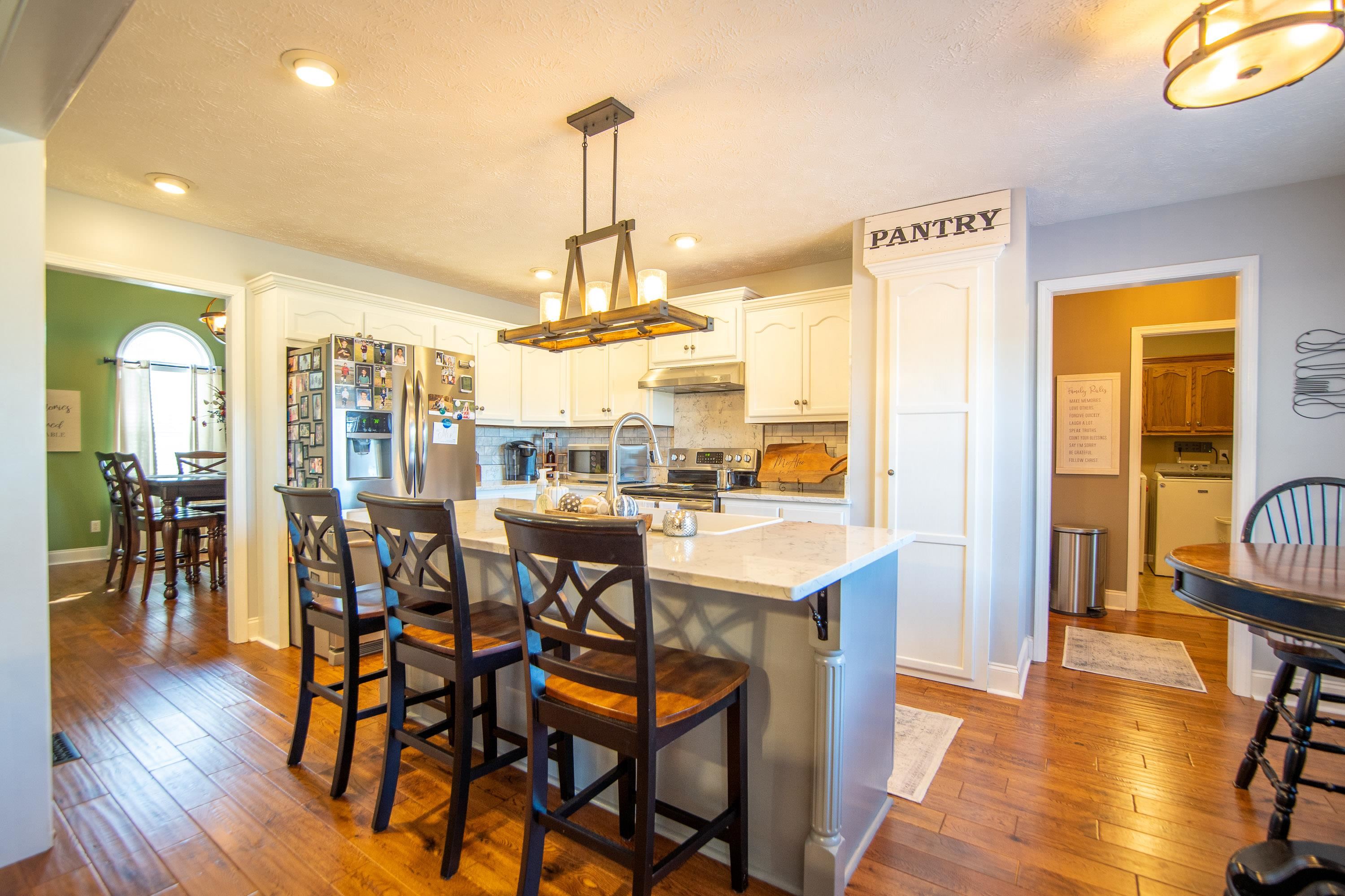 6843 Michie Pebble Hill Road Michie, TN 38357 - Photo 3 of 25 a view of a dining room and livingroom with furniture wooden floor a chandelier