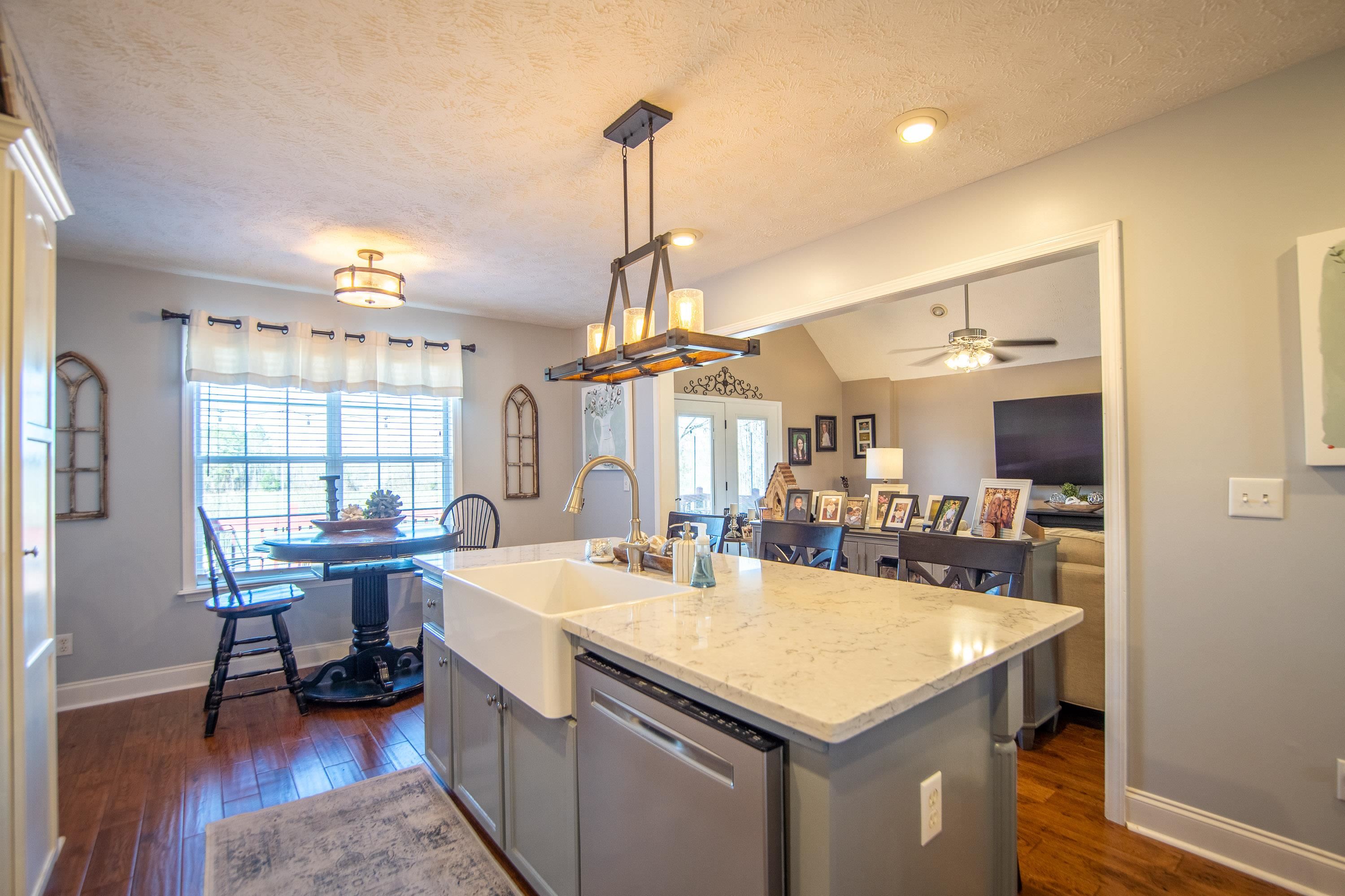 6843 Michie Pebble Hill Road Michie, TN 38357 - Photo 4 of 25 a kitchen with a sink a counter and chairs