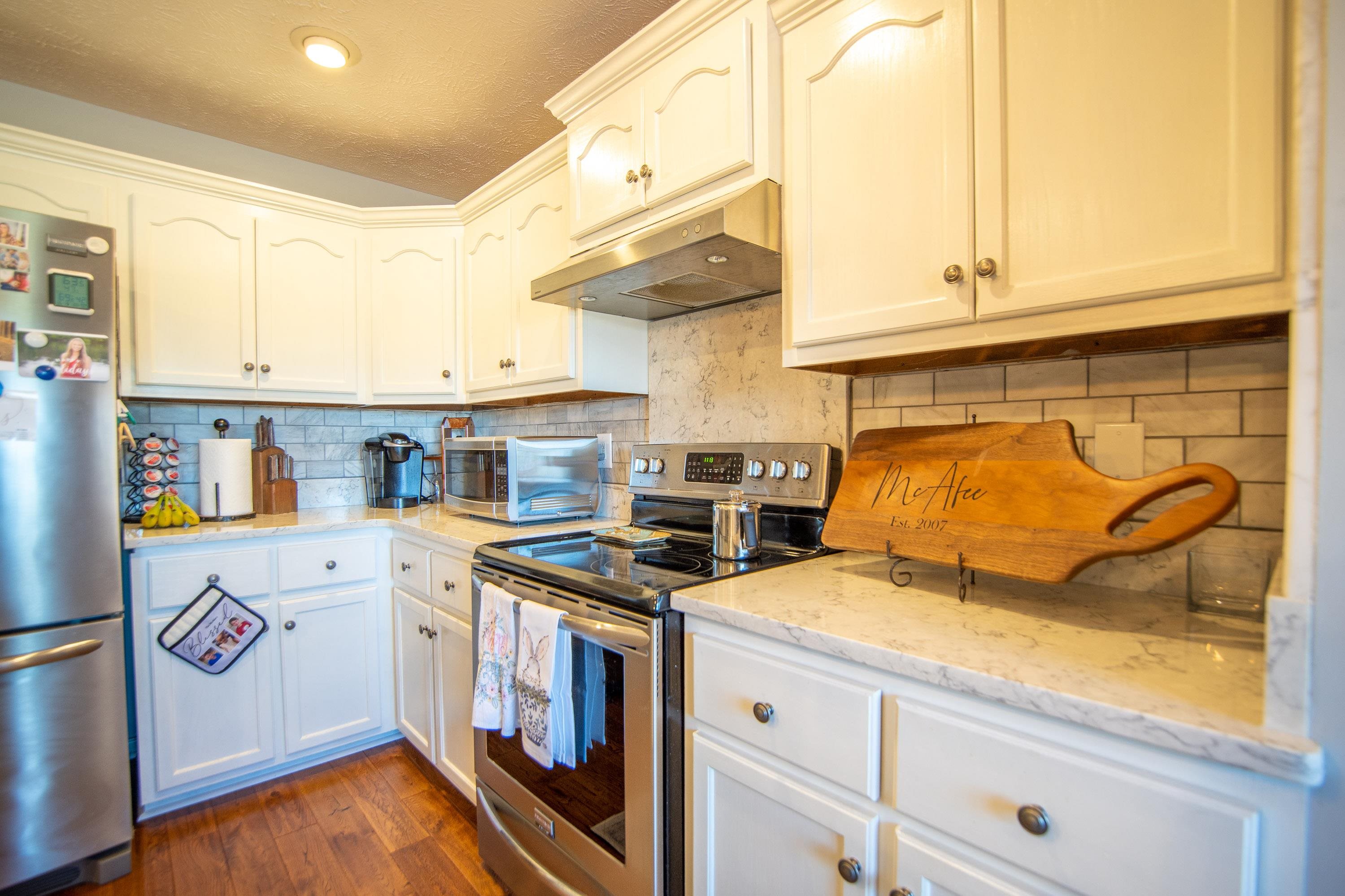 6843 Michie Pebble Hill Road Michie, TN 38357 - Photo 5 of 25 a kitchen with stainless steel appliances granite countertop a stove and a white refrigerator