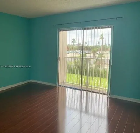 a view of a room with wooden floor and a window