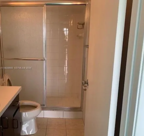 a bathroom with a granite countertop shower and a toilet