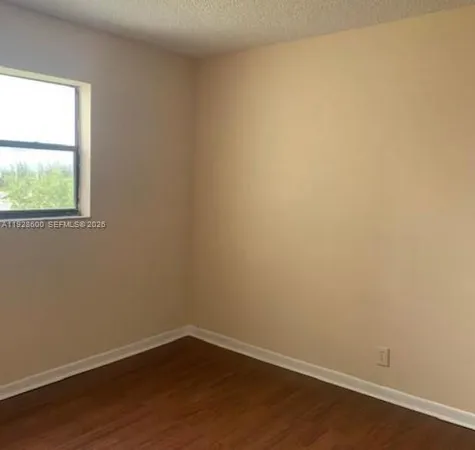 a view of a small space with wooden floor and a window
