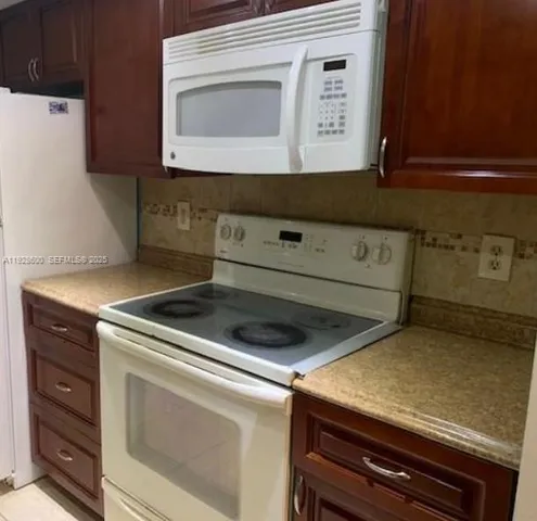 a view of kitchen cabinets and a stove top oven
