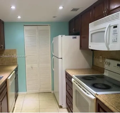 a kitchen with granite countertop a refrigerator and a stove