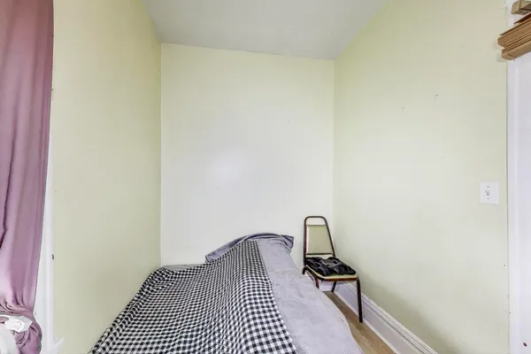 a view of a bedroom with a bed and wooden floor