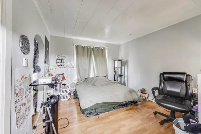 a kitchen with stainless steel appliances a refrigerator a stove a sink a dining table and chairs with wooden floor