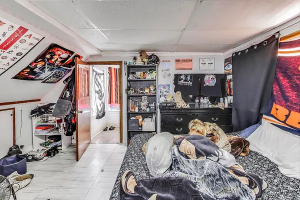 a bedroom with a bed and a painting on the wall
