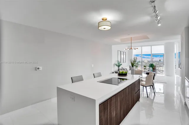 a kitchen with a sink a counter top space and living room