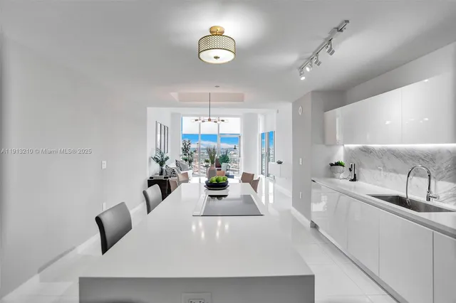 a large white kitchen with a large window