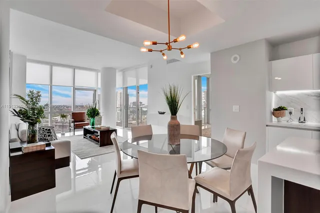 a dining room with furniture a large window and wooden floor