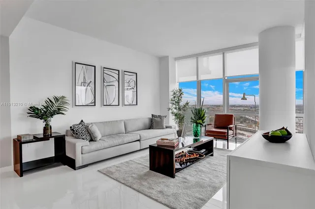 a living room with furniture and a floor to ceiling window