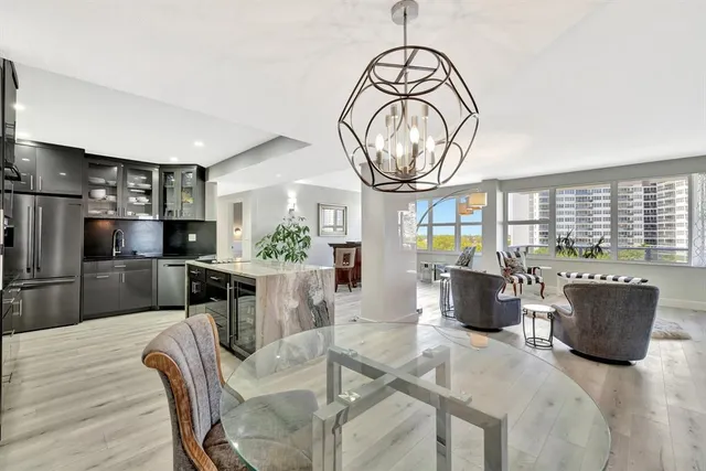 a dining room with furniture a chandelier and wooden floor