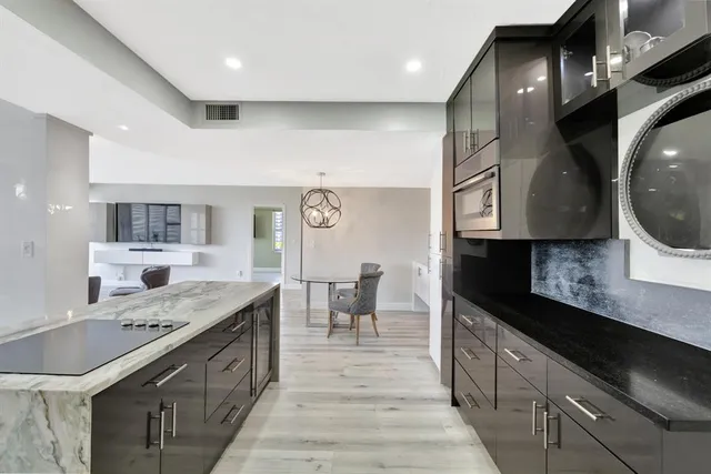 a large kitchen with stainless steel appliances kitchen island granite countertop a sink and cabinets