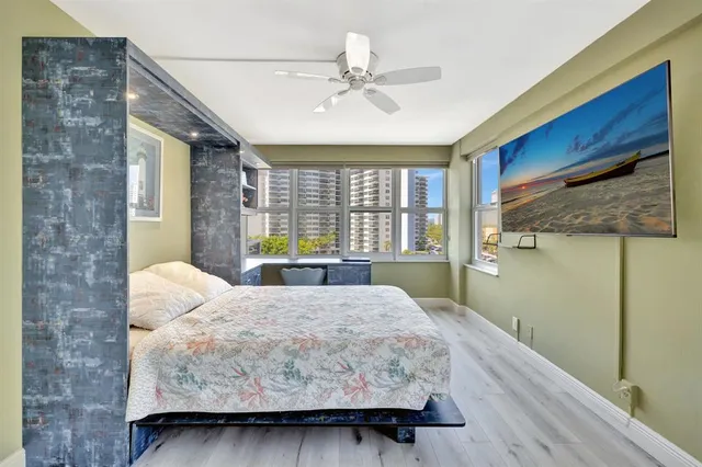 a bedroom with a bed and a large window