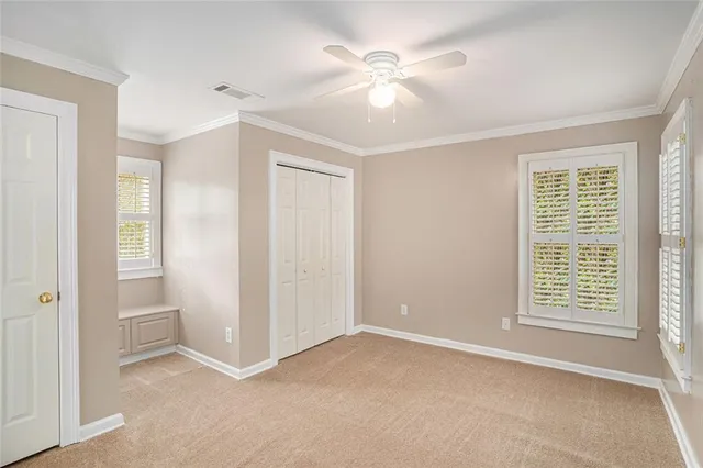 an empty room with windows and fan