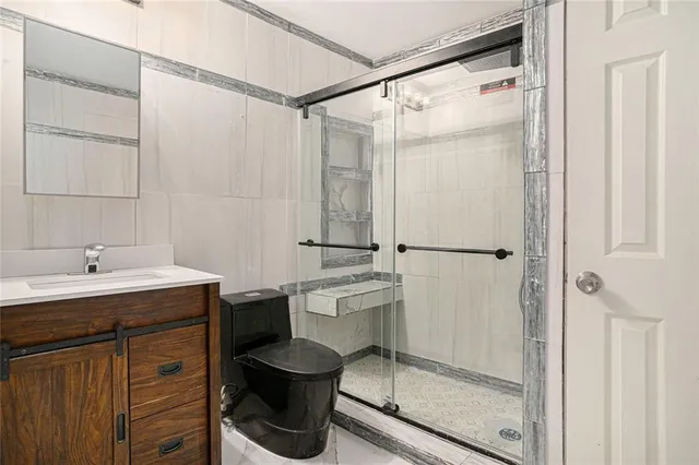 a bathroom with a granite countertop sink toilet and shower
