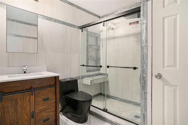 a bathroom with a granite countertop sink toilet and shower