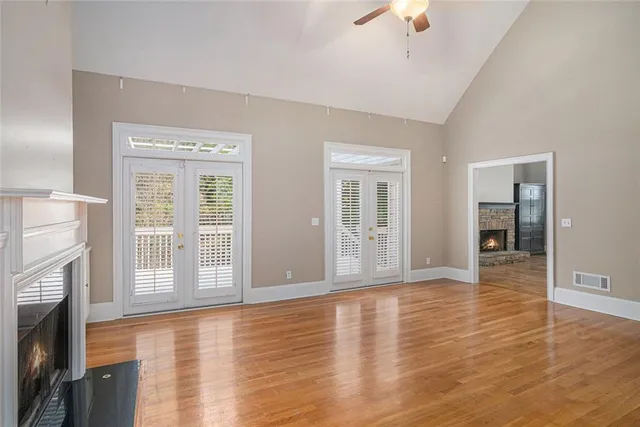a view of an empty room with window and wooden floor