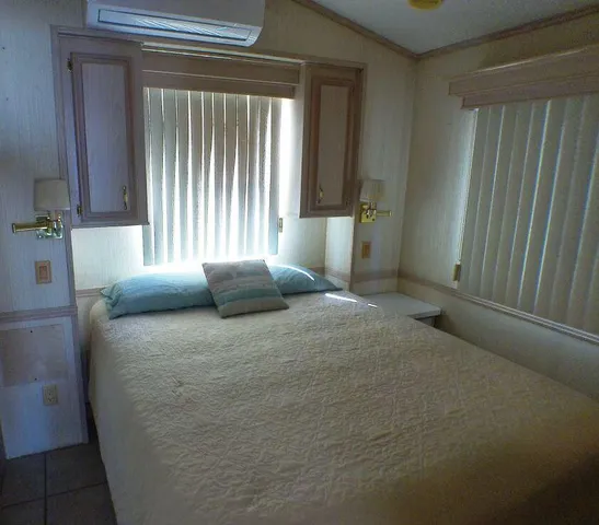 a large bed sitting in a bedroom next to a window