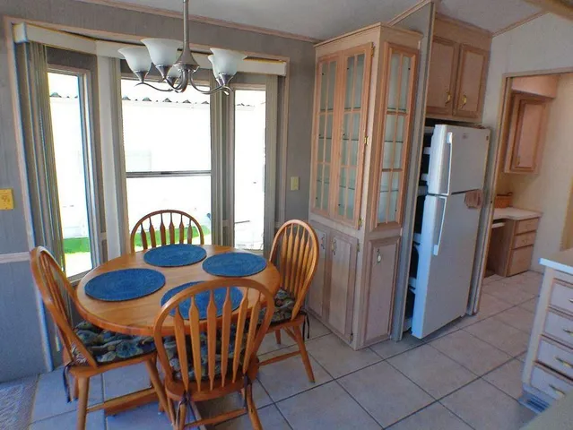 a dining room with furniture a chandelier and wooden floor