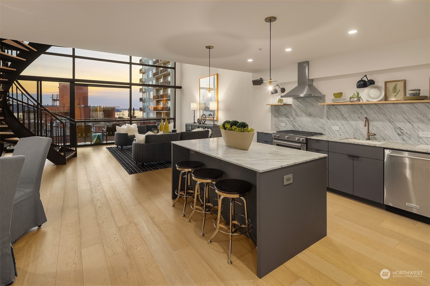 80 Vine Street, Unit 502 Seattle, WA 98121 - Photo 7 of 31 a kitchen with kitchen island granite countertop a sink cabinets and wooden floor